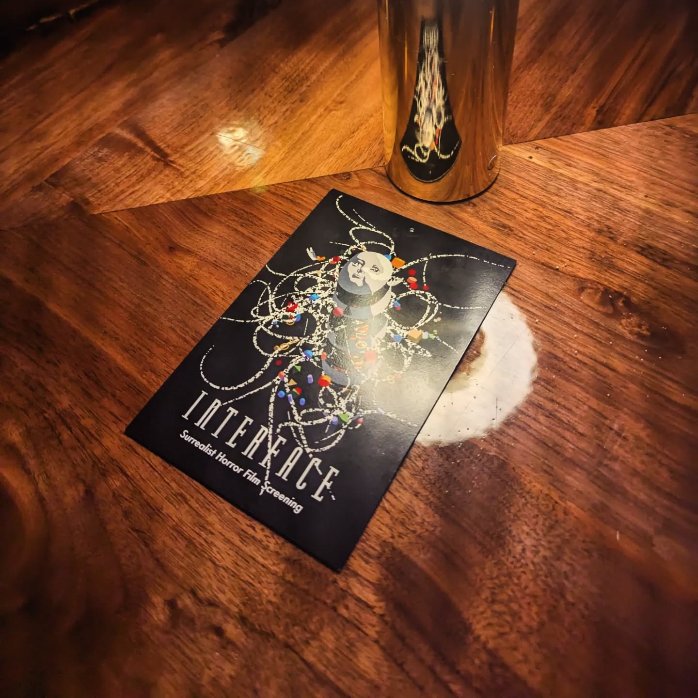 The Interface postcard on a wooden table