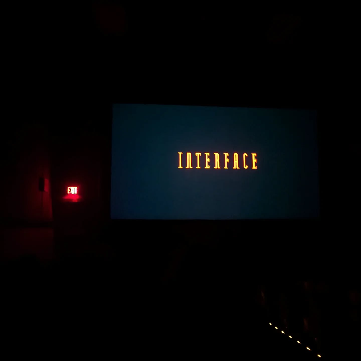 The title Interface on the screen at the Esquire, in the dark